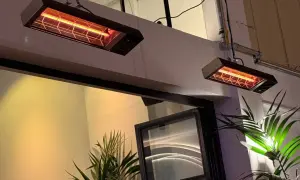 Dwa wiszące promienniki ciepła elektryczne emitują przyjemne, pomarańczowe światło, ogrzewając przestrzeń.