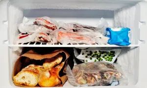 Zamrożone mięso, pieczywo, groszek i inne produkty spożywcze w zamrażarce.
