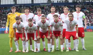 Młoda drużyna piłkarska w biało-czerwonych strojach, gotowa do gry. W tle trybuny stadionu, gdzie kibice dopingują lublin klub piłkarski.