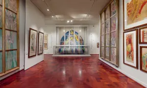 Wnętrze muzeum Wyspiańskiego w Krakowie. Witraże, rysunki i tkaniny zdobią ściany.