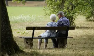 Para, starsza para siedzi na ławce w parku, marząc o przyszłości. Marzenia o podróżach, o wnukach, o spokoju. A może o tym, że pożyczka dla każdego bez odmowy pomoże im zrealizować te plany.