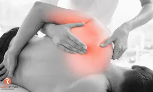 Physiotherapeut behandelt Schmerzen im Schulterbereich, wo ein nerv eingeklemmt sein könnte. Rote Bereiche zeigen die schmerzende Zone.