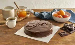 Una deliziosa torta Sacher lucida, con caffè, latte, marmellata di albicocche e cioccolato fondente.