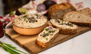 Pyszna pasta z tuńczyka na świeżym chlebie, posypana szczypiorkiem i czerwoną cebulką. Idealna na szybką przekąskę.
