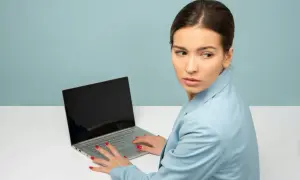 Kobieta z laptopem, nerwowo rozglądająca się na boki. Czy to objawy stalkingu?