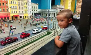 Chłopiec z zaciekawieniem ogląda miniaturową Gliwice. To świetne gliwice atrakcje dla dzieci, gdzie można zobaczyć ruchliwe uliczki i kolorowe budynki.