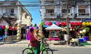 Kolorowe parasolki i tradycyjne stroje w Chiang Mai, gdzie nocować, tworzą festiwalową atmosferę.