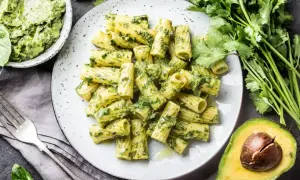 Pyszny makaron rigatoni z zielonym pesto, podany z awokado i świeżą kolendrą. Idealna ilość pesto do makaronu.