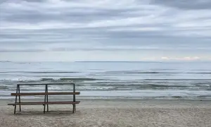 Pusta ławka na plaży w Jelitkowie zaprasza do podziwiania fal. To idealne miejsce na relaks i odkrywanie uroków tego nadmorskiego kurortu.