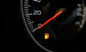 Na desce rozdzielczej świeci się pomarańczowa kontrolka rezerwy paliwa, sygnalizując niski poziom paliwa w baku.