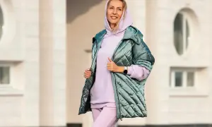 Kobieta w pastelowym dresie i błyszczącej kurtce. Idealny zestaw, który udowadnia, że botki do dresów to świetny wybór na co dzień.