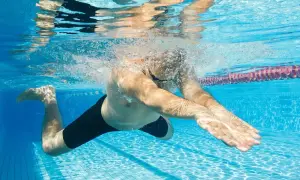 Podwodny widok pływaka wykonującego ruchy nóg i rąk, idealny do nauki pływania żabką.