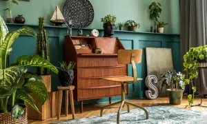 Biurko z lat 70. i krzesło w stylu vintage, otoczone bujną zielenią. Wnętrze emanuje ciepłem i nostalgicznym urokiem.