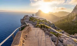 Sonnenuntergang über dem Meer, ein Pfad mit Treppen führt zu Aussichtspunkten. Perfekte Reiseziele im Februar für atemberaubende Ausblicke.