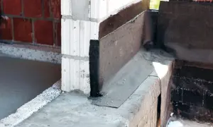 Papa na fundament chroni przed wilgocią, widoczna na narożniku budowy.