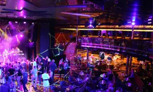 En livlig scen med ett band som spelar, folk som dansar och sitter vid bord. En trappa leder upp till en annan nivå. En typisk bild av stockholm nightlife.