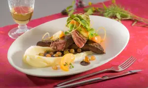 Ein köstliches Kalbsleber Rezept mit Sauce, serviert mit Kartoffelpüree, Apfelspalten und frischen Kräutern.
