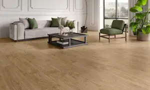 Elegante salón con sofá gris, mesa de centro y sillón verde, sobre un cálido pavimento SPC de madera.