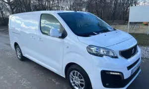 Biały Peugeot Expert 2.0 HDI gotowy do pracy. W tle drzewa i plac zabaw.