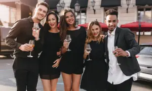 Fünf Freunde in eleganter Cocktailgarderobe stoßen mit Champagner an.
