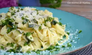 Assiette de tagliatelle de courgette crémeuse, parsemée de persil frais et de parmesan râpé. Un délice léger et savoureux.