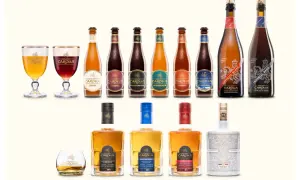 Una selezione di birre e whisky Gouden Carolus, con il loro iconico anker, in bottiglie e bicchieri eleganti.