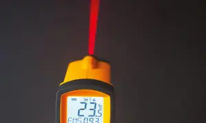Żółty pirometr z czerwonym laserem i wyświetlaczem pokazującym 23.5°C.