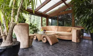 Gemütlicher Wintergarten mit üppiger Bepflanzung, bequemer Couch und einem einzigartigen Couchtisch. Tolle Ideen für Ihren Wintergarten!