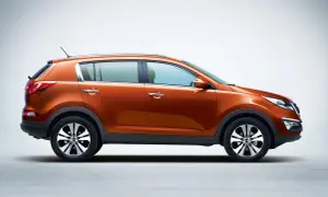 Pomarańczowy Kia Sportage 2013 z profilu, z błyszczącymi felgami i chromowanymi klamkami, gotowy na przygodę.