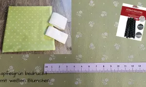Apfelgrüner Stoff mit weißen Blümchen, ideal für eine Dirndlschürze. Ein Schnittmuster liegt bei.