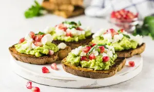 Tosty z guacamole, serem feta i granatem – idealne z czym jeść guacamole na śniadanie lub przekąskę.