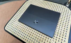 Ciemny tablet z logo Windows na plecach, działający na Windows 11 ARM, leży na plecionej powierzchni.