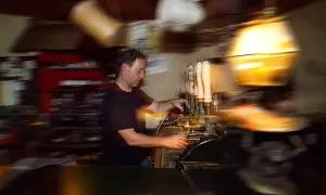 Barista serve birra a un beer fest, con spillatori e bicchieri in movimento.