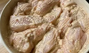 Rå kycklingbitar i en krämig marinad. Denna yoghurtmarinerade kyckling ser ut att bli otroligt saftig och smakrik.