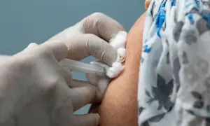 Ręka w rękawiczce medycznej podaje zastrzyk. To ważny krok w kierunku zakończenia pandemii, dzięki szczepieniom covid.
