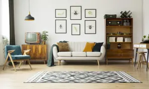 Przytulny salon retro z kanapą, fotelem i meblami z lat 60. Obrazy z owadami i paprociami dodają uroku.
