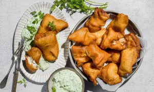 Fritti dorati di lucioperca, perfetti per le tue ricette. Serviti con salsa verde e guarniti con prezzemolo fresco.