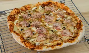 Pyszna pizza z szynką, pieczarkami, oliwkami i ananasem. Idealna na rodzinny obiad, zastanawiasz się ile piec pizze?