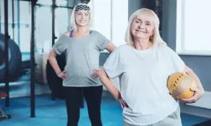 Dwie starsze kobiety ćwiczą na siłowni. Jedna trzyma piłkę. Może to być związane z tabletkami na menopauzę po których się chudnie.