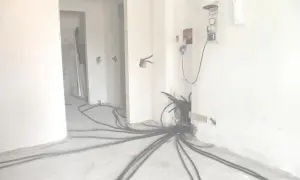 Rifacimento impianto elettrico in corso. Cavi neri si diramano dal muro, pronti per la manutenzione ordinaria o straordinaria.