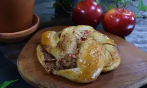 En gyllene kanelbulle med äppelbitar, redo att avnjutas.