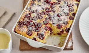 Ein goldbrauner Grießauflauf mit Kirschen, bestäubt mit Puderzucker. Dieses Grießauflauf Rezept sieht köstlich aus!