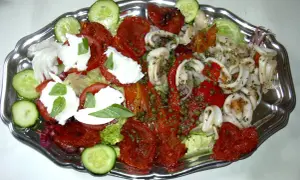 En härlig anti pasti-tallrik med bläckfiskringar, mozzarella, tomater och gurka.