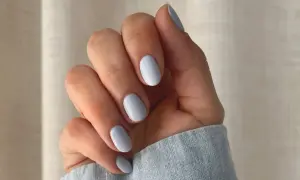 Dłoń z paznokciami w delikatnym baby blue kolorze.