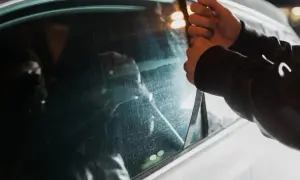 Ręce zdejmują szybę z samochodu. Zastanawiasz się, ile czasu trwa śledztwo w sprawie kradzieży auta?