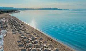 Ein traumhafter Strand mit vielen Liegen und Sonnenschirmen, bereit für Gäste des TUI Blue Lagoon Princess. Das Meer glitzert in der Sonne.