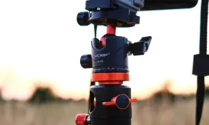 Część głowicy trójnoga fotografa K&F Concept KF-28 z pomarańczowymi akcentami, gotowa do uchwycenia zachodu słońca.