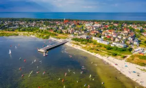 Jastarnia atrakcje: wiatr, deski i słońce na Zatoce Puckiej. Widok na molo, plażę i miasteczko.