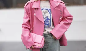 Giacca rosa in ecopelle, che dimostra il suo significato di alternativa sostenibile alla pelle animale. Borsa coordinata e jeans.
