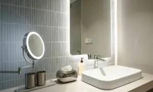 A modern bathroom vanity with a lighted makeup mirror, showcasing the best bathroom lighting for makeup.